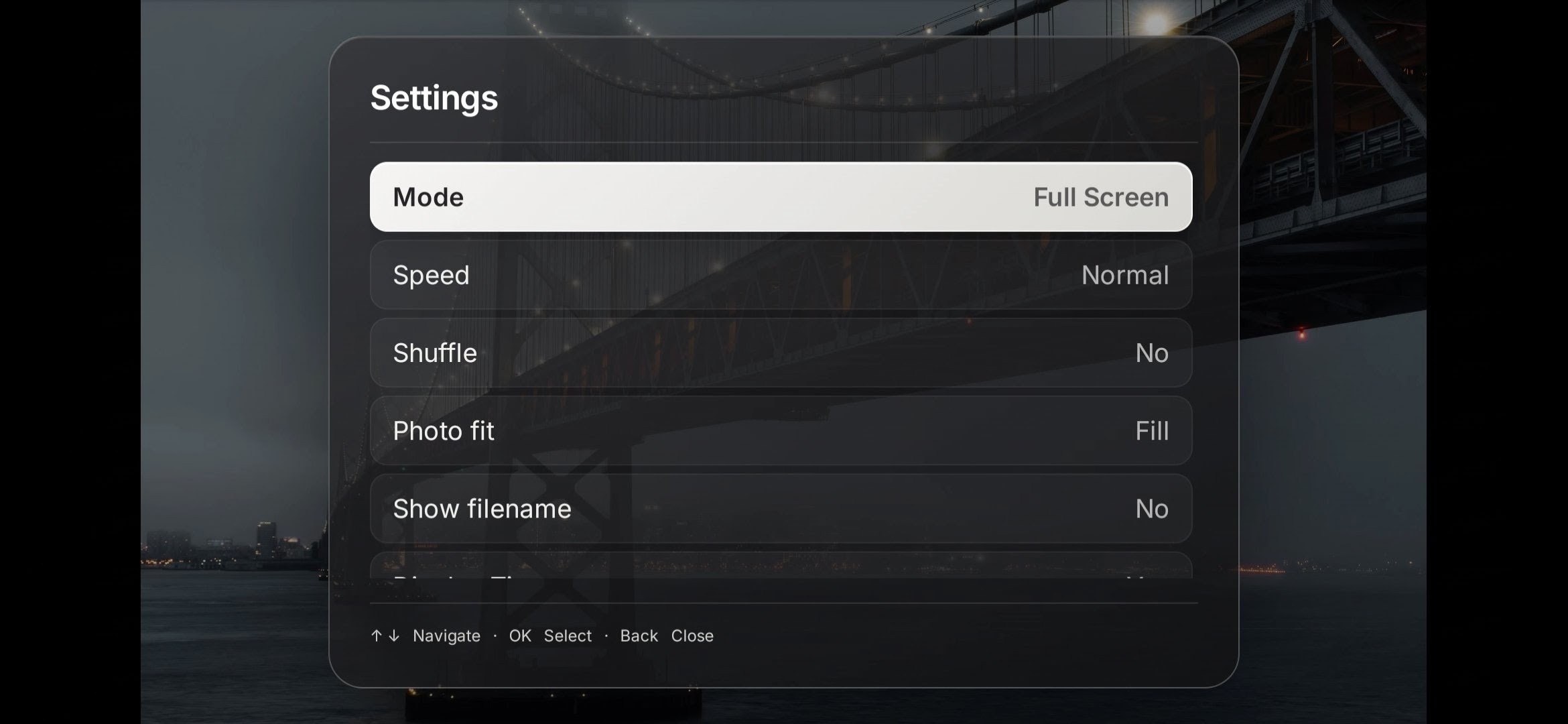 PictaCast's on-TV Settings menu over a bridge photo, showing Mode, Speed, Shuffle, Photo fit, and Show filename